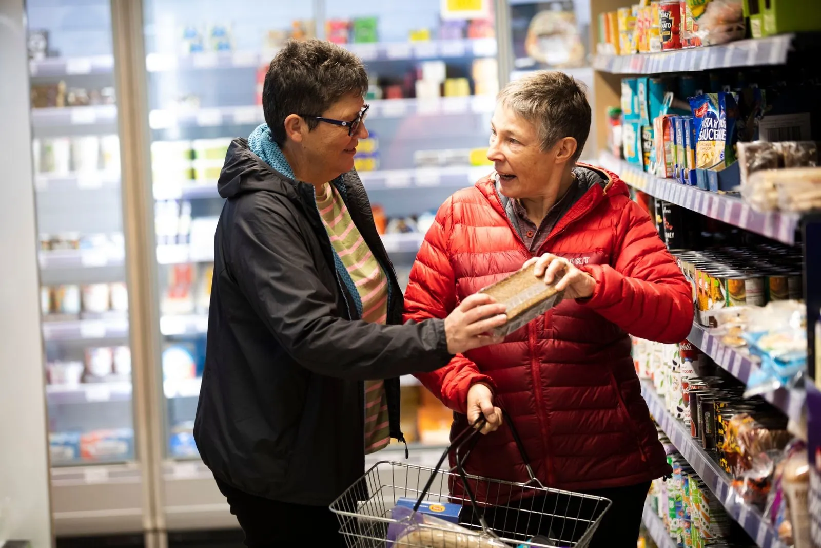 Caregiver grocery shopping with a senior woman